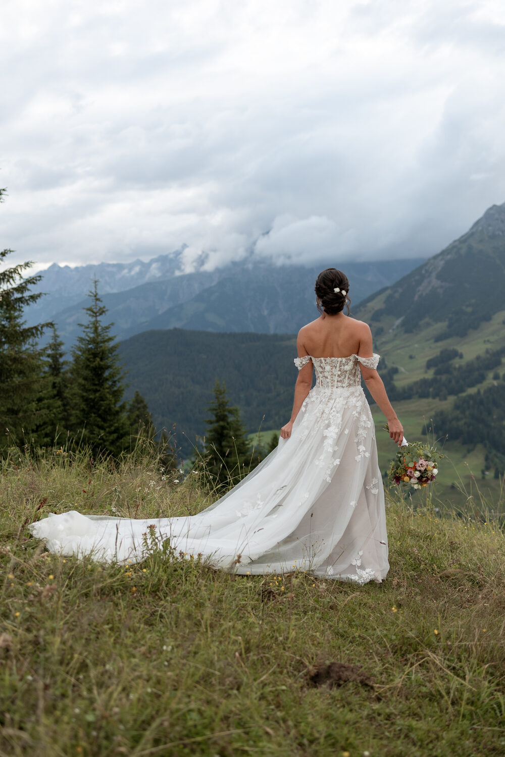 Braut mit Schleppe vor Alpenkulisse